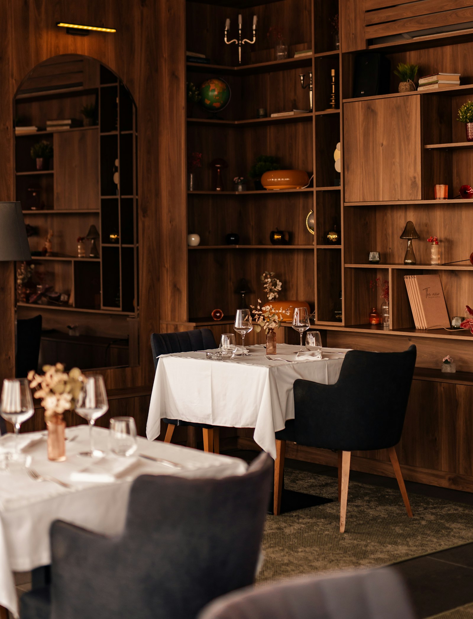 Dining tables with white cloths in a wood-paneled room