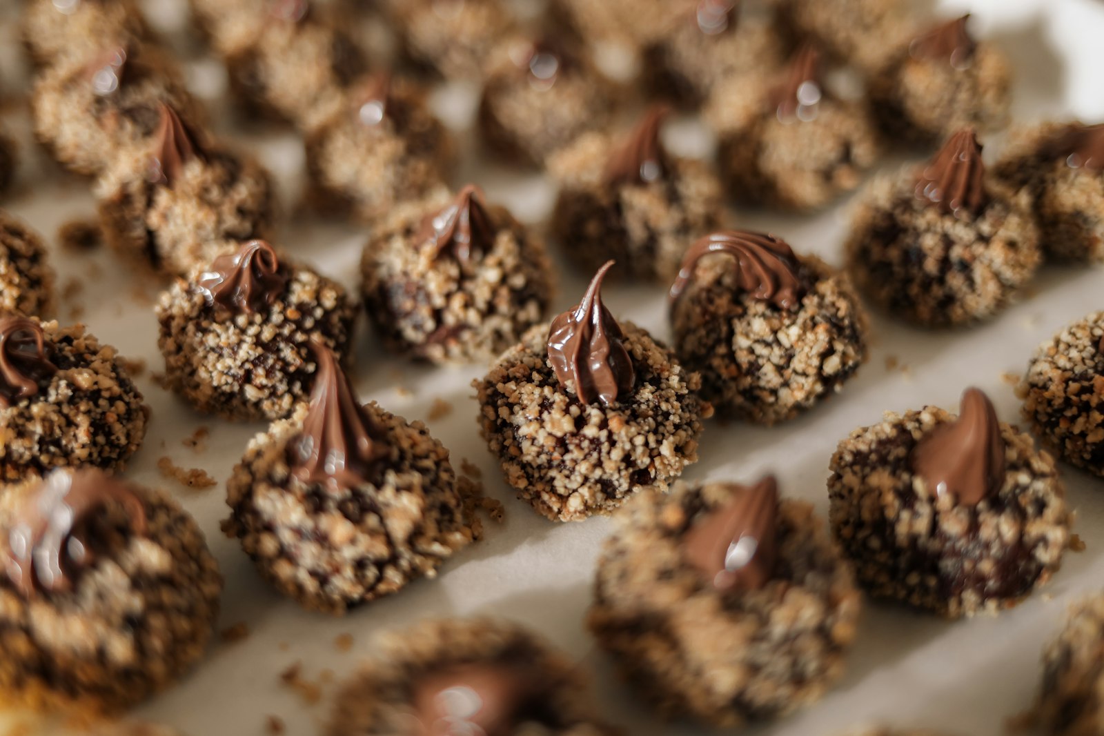 Chocolate-topped nut sweets on a tray